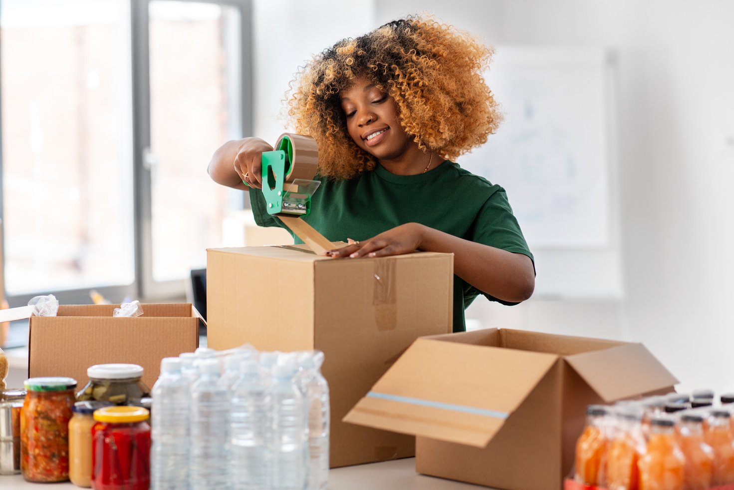 Volunteer Woman Packing Food in Donation Boxes